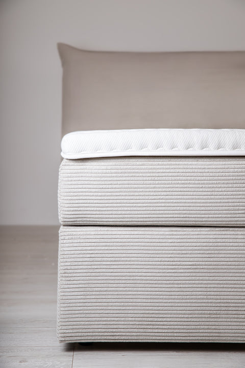 Bed met gestoffeerde matras en losse topper
